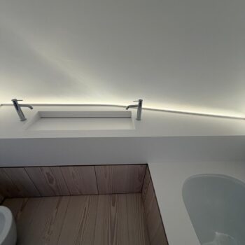 Close-up of a Corian washbasin trough with a concealed slot drain, with no visible plug or trap