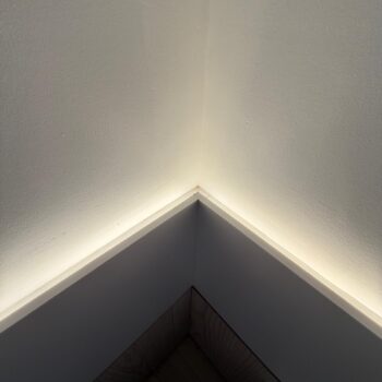 Detail of the junction between the Corian worktop and the wall, with linear LED lighting concealed in the reveal