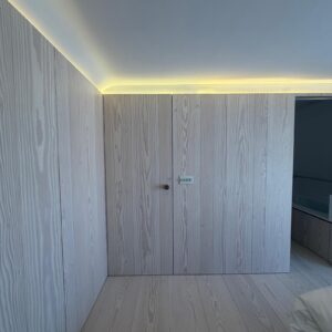 Whitewashed timber panelling to the walls and doors leading into the bathroom with its Corian washbasin and bath