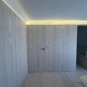 Whitewashed timber panelling to the walls and doors leading into the bathroom with its Corian washbasin and bath