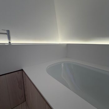 Bath set into a Corian worktop with a raised upstand protecting the wall from splashes